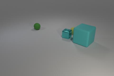 CLEVR scene: a green sphere at back left, a small yellow cube partly hidden behind a small cyan metal cube, and a large cyan cube on the right, on a neutral floor.